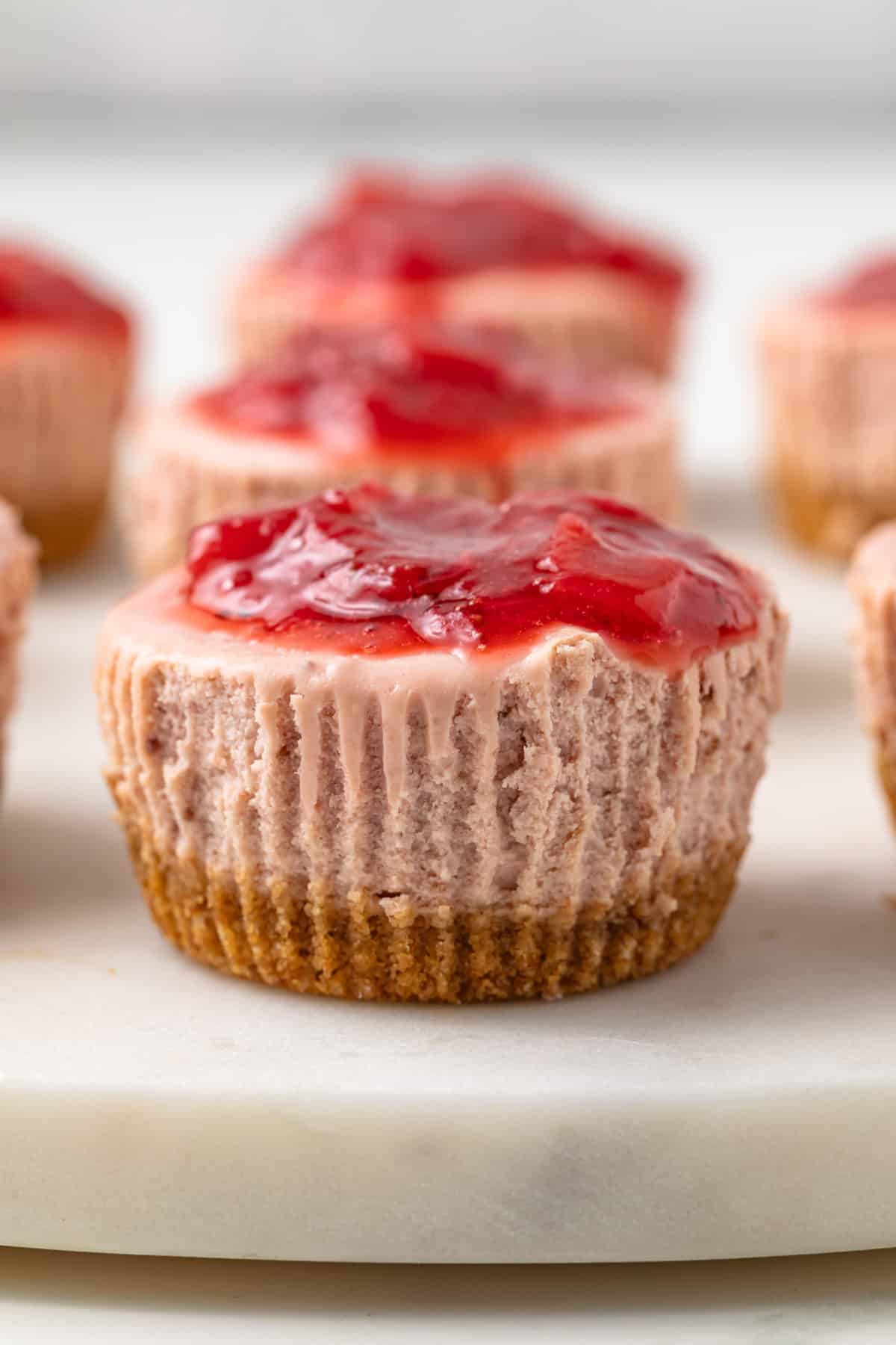 Close up of mini strawberry cheesecake with strawberry topping.