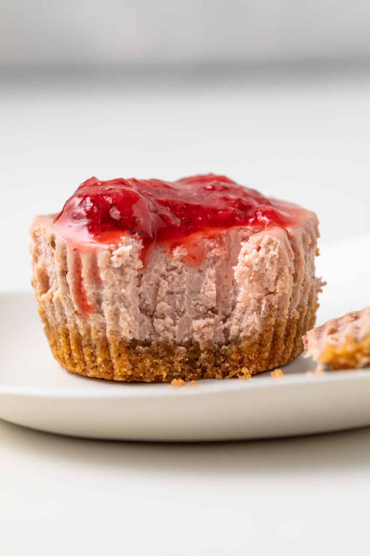 Mini strawberry cheesecake with bite taken out.