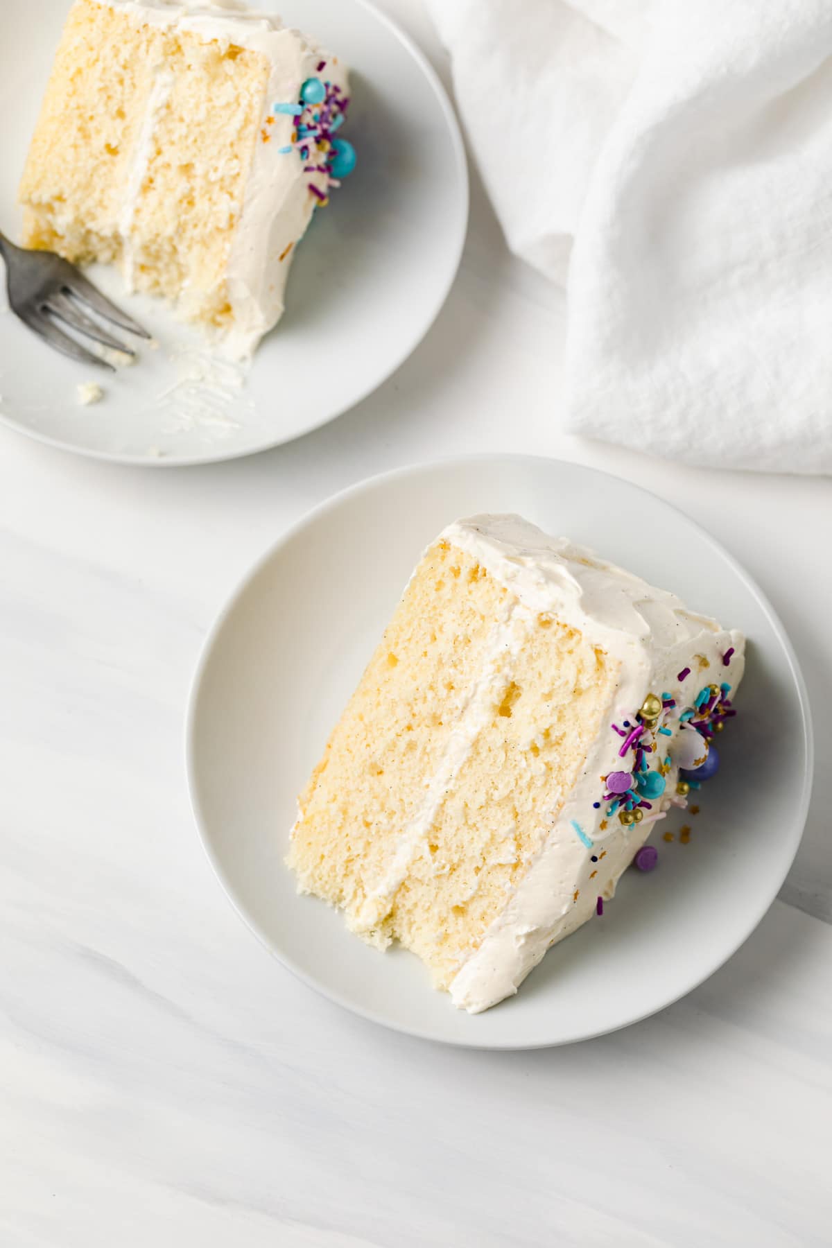 angled view of slice of moist vanilla cake on a white plate