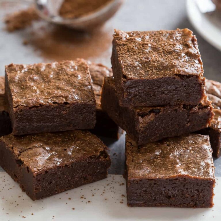 Close-up view of Homemade Brownies with Nutella stacked on a white cutting board.