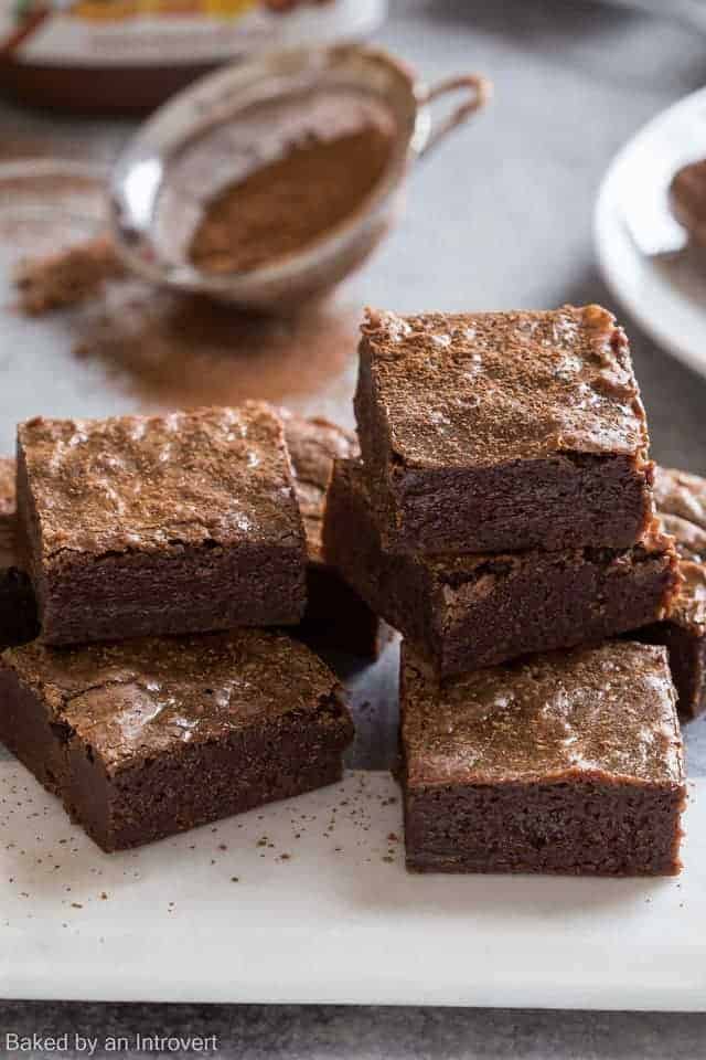 Close-up view of Homemade Brownies with Nutella stacked on a white cutting board.