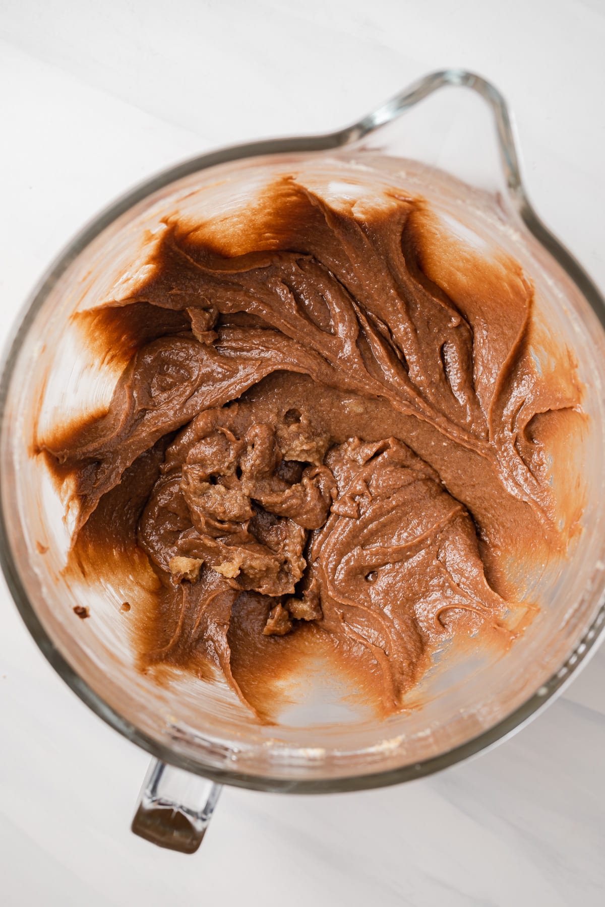 Wet ingredients for cookie dough mixed in glass bowl.