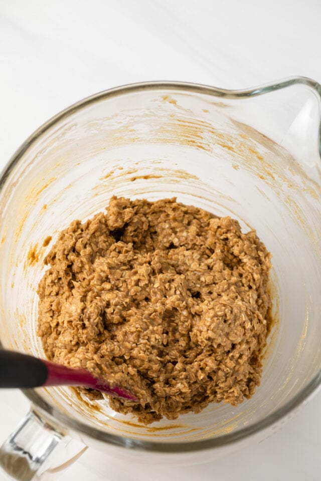 Oatmeal cookie batter in glass bowl.
