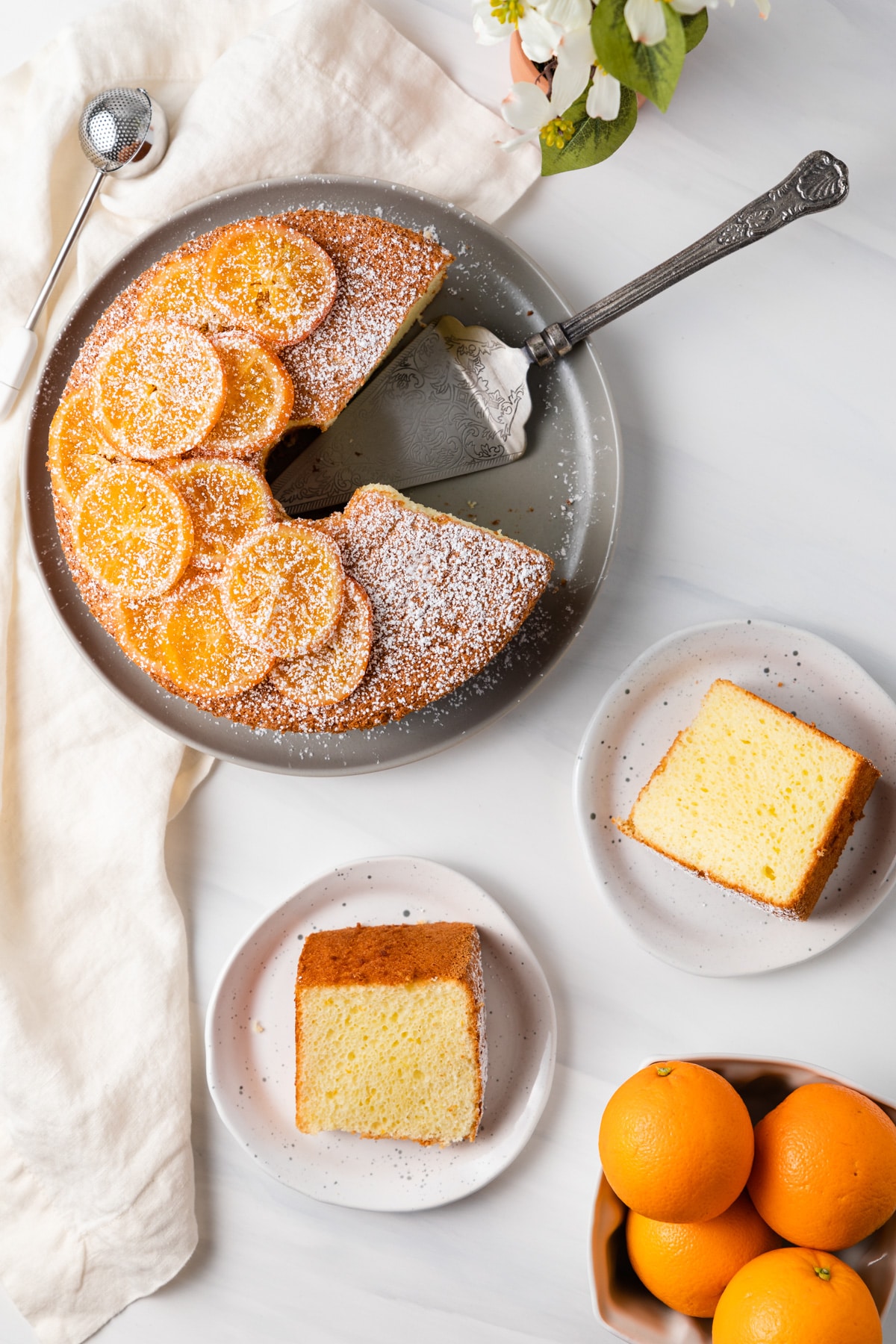 overhead of orange chiffon cake next to two slices on plates