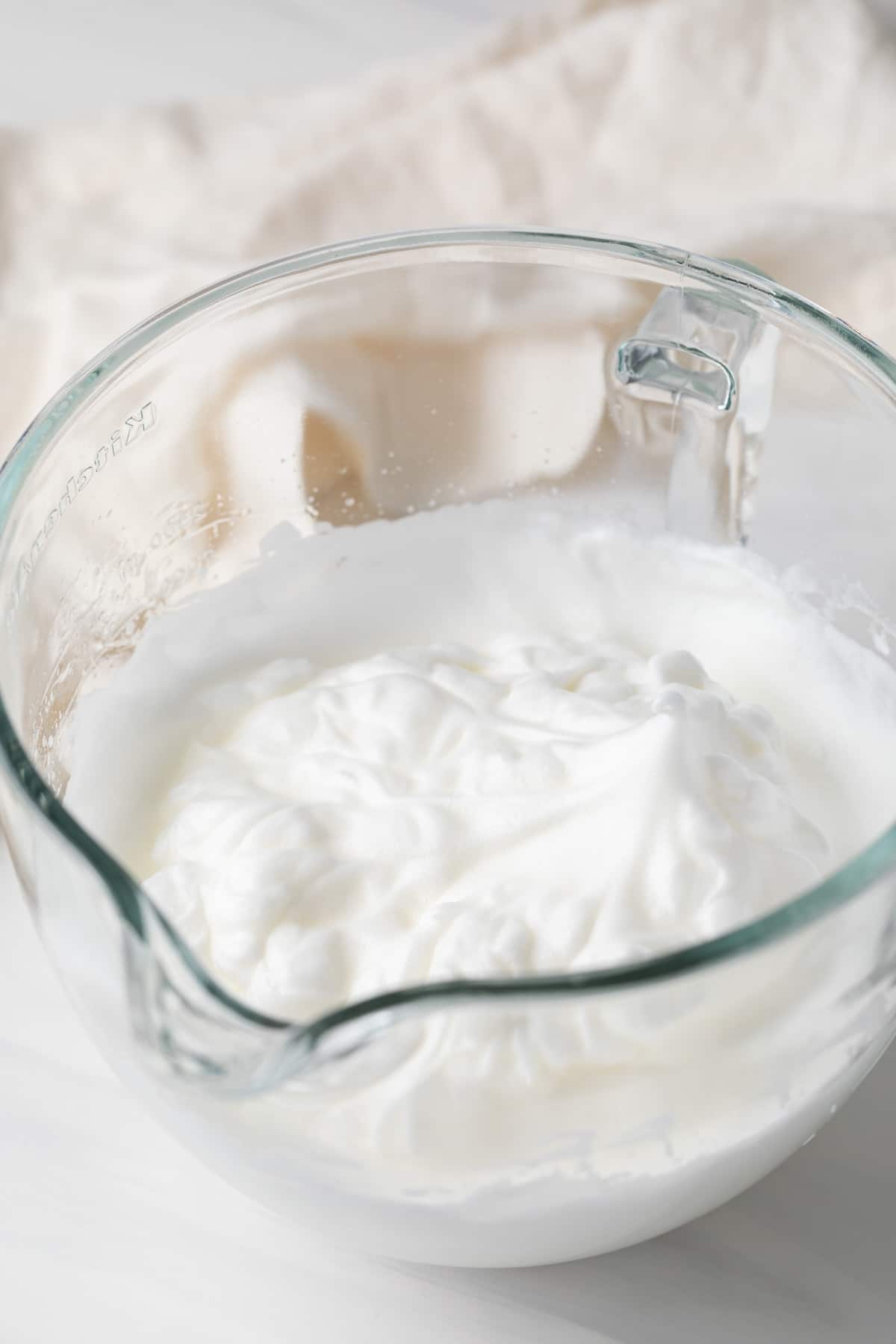 whipped egg whites in glass bowl