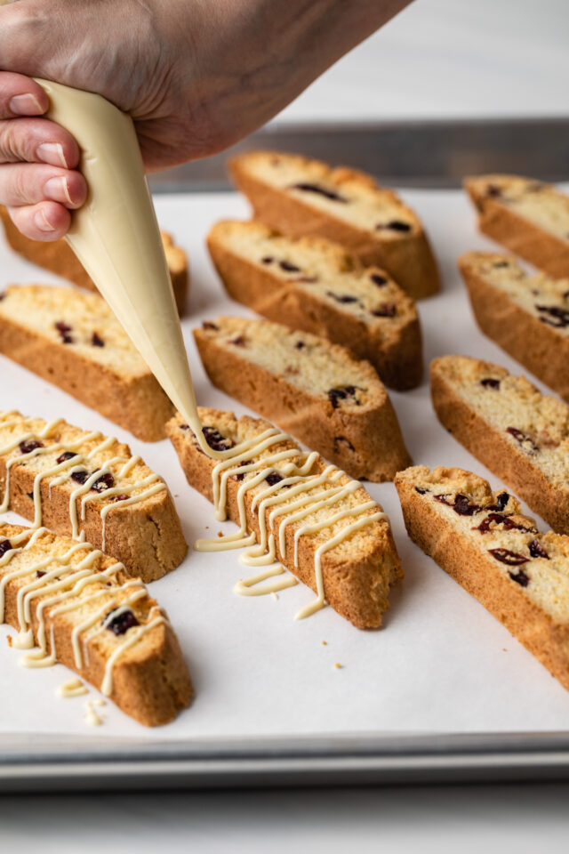 A hand piping white chocolate