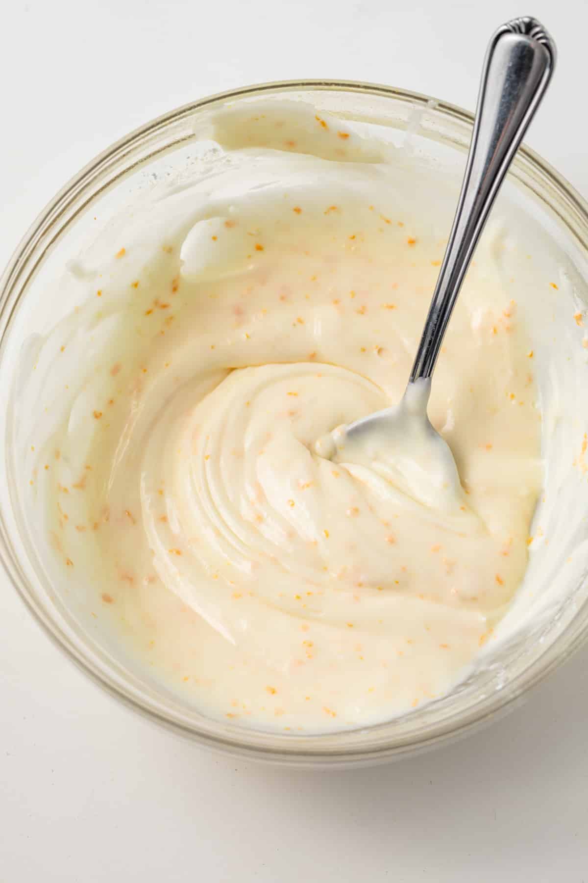 Orange icing in glass bowl.