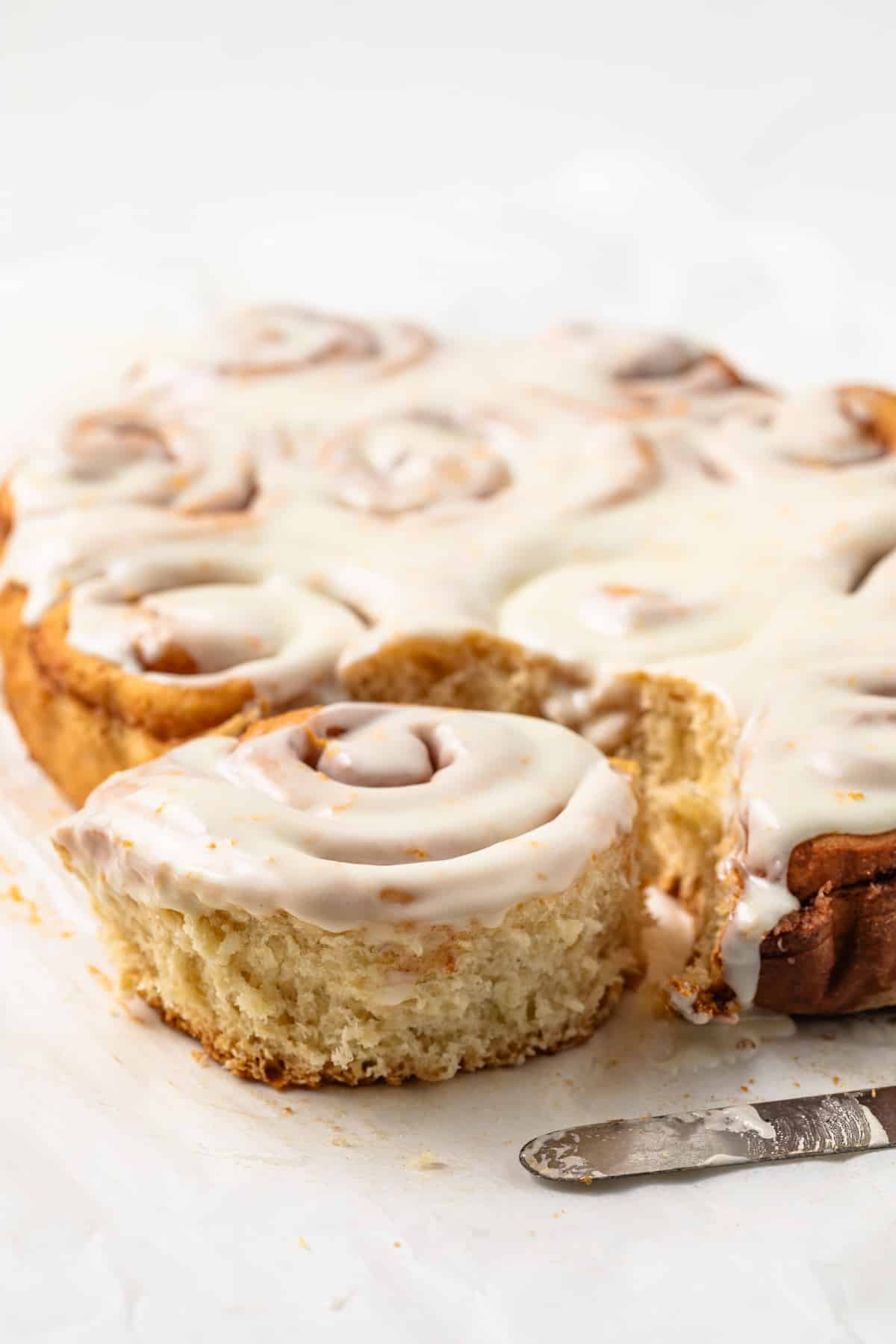Side view of glazed orange sweet rolls.