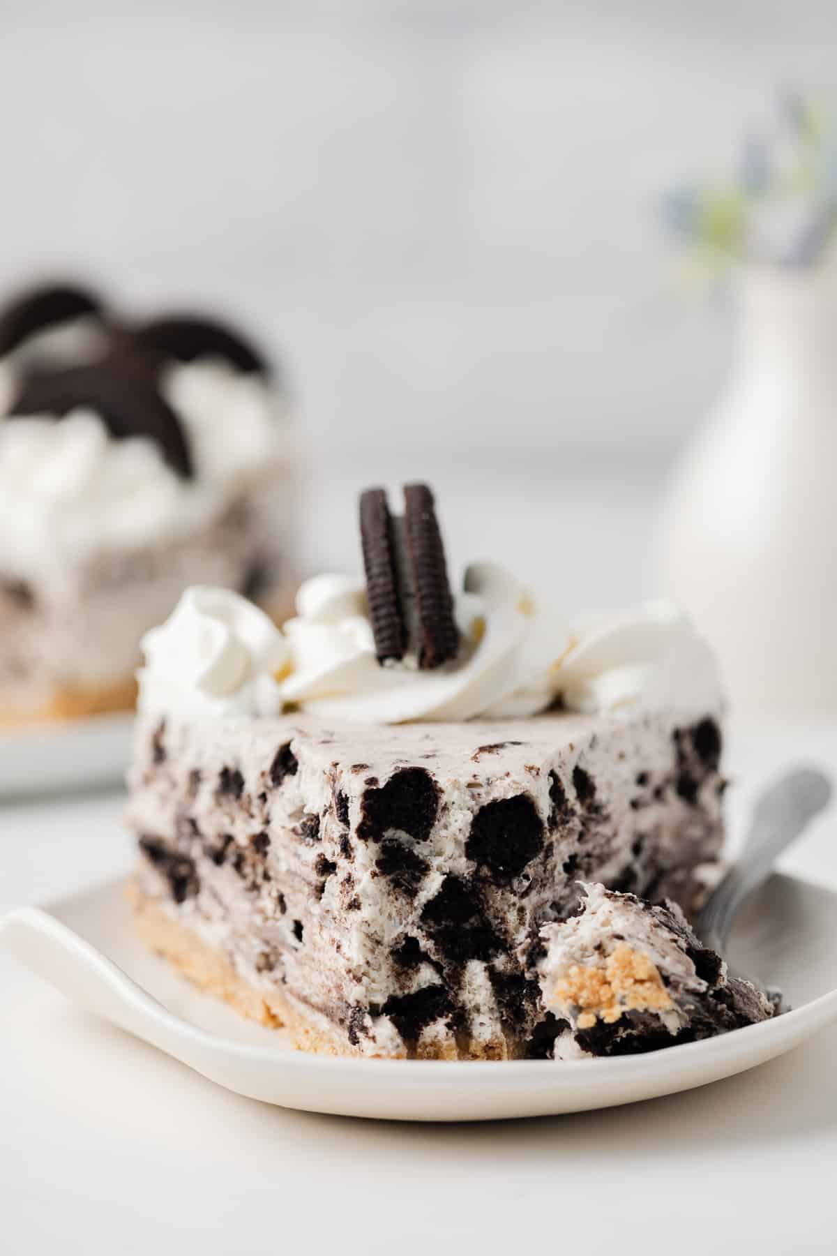 Slice of no bake Oreo cheesecake with bite taken out.