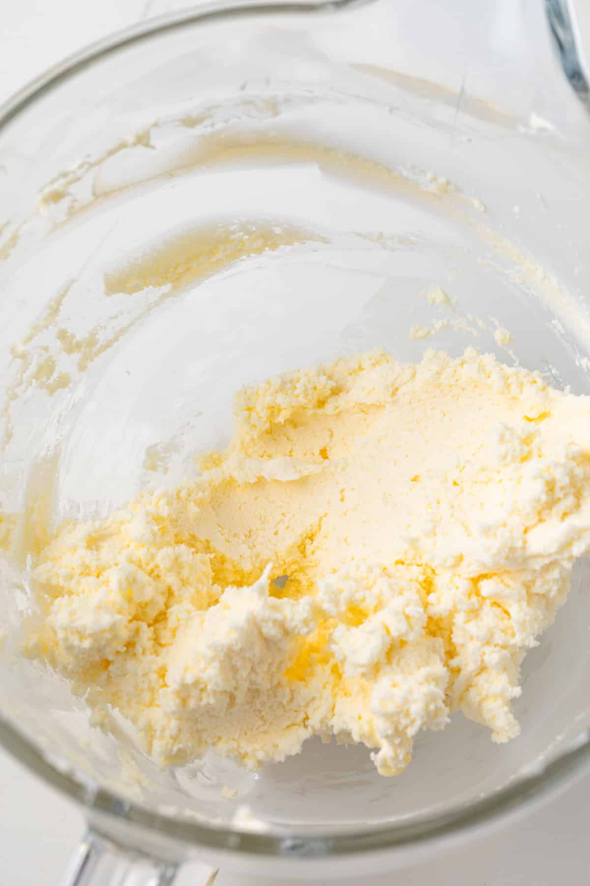 Creamed butter and cream cheese in a glass bowl.