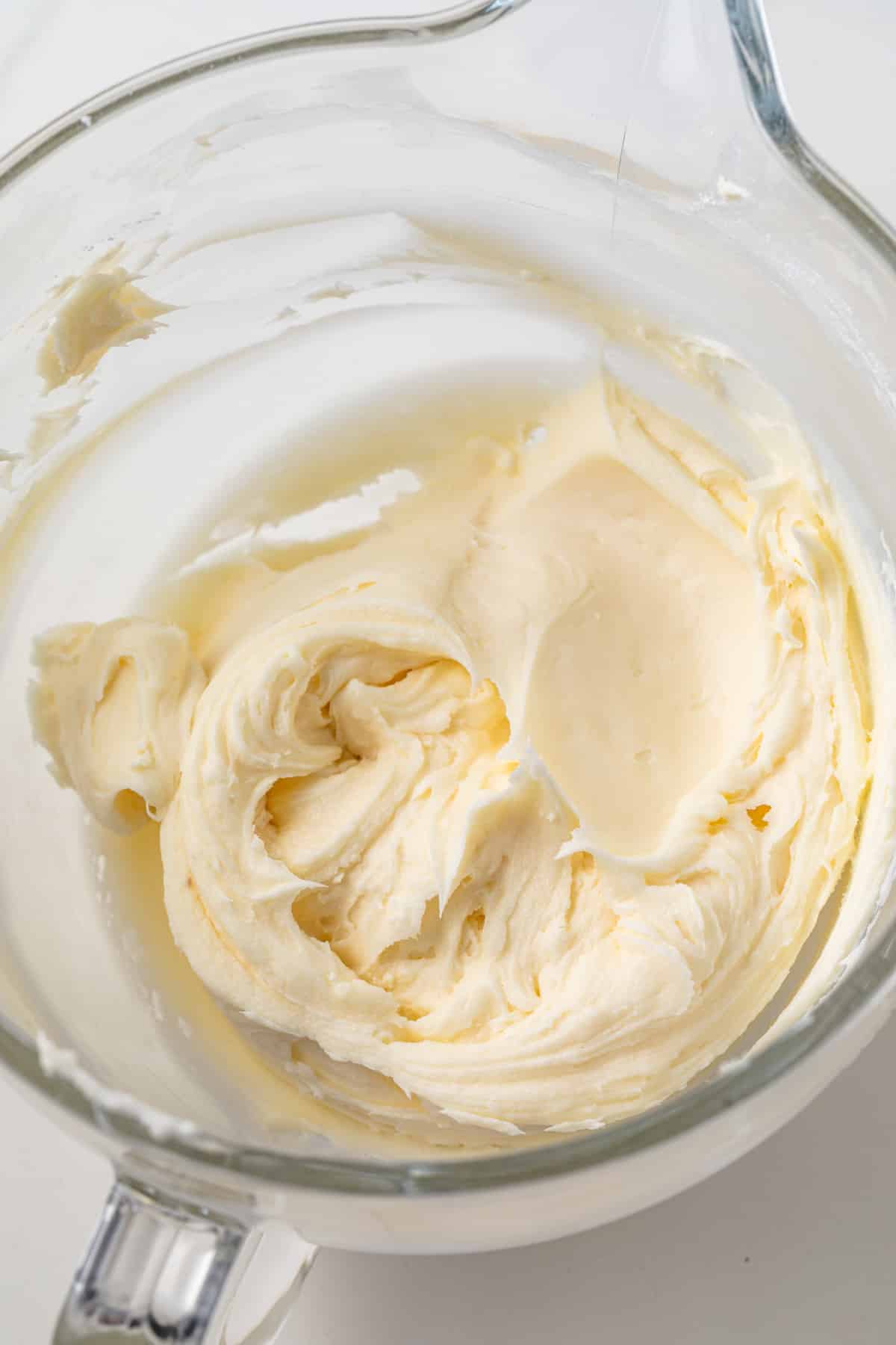 Cream cheese frosting in a glass bowl.