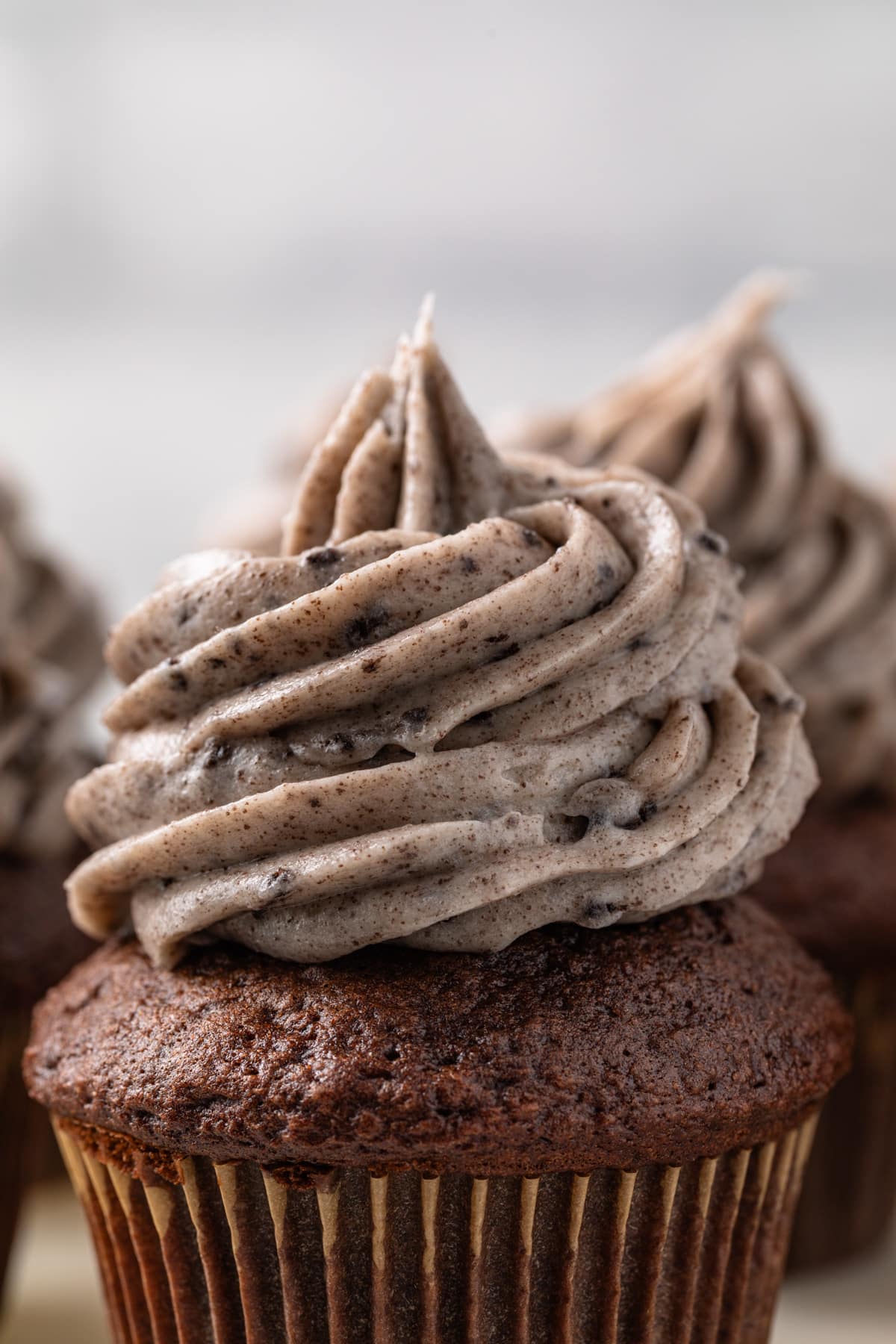 Close up of Oreo frosting swirled over chocolate cupcakes.
