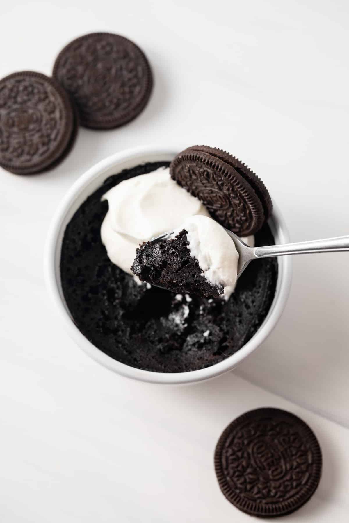 Spoon taking out a bite of Oreo mug cake.