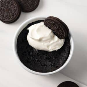 Overhead of Oreo mug cake topped with whipped cream.