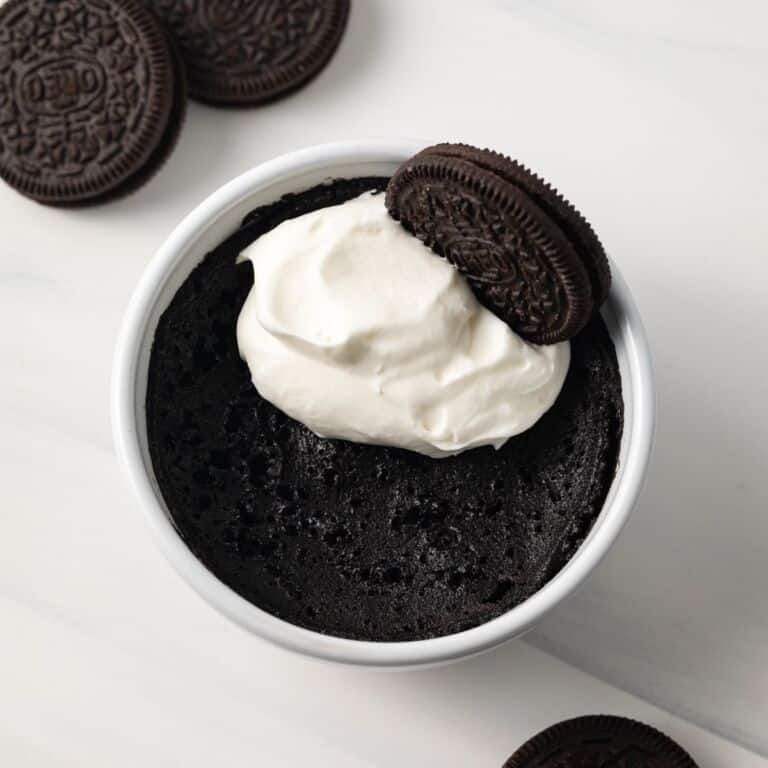 Overhead of Oreo mug cake topped with whipped cream.