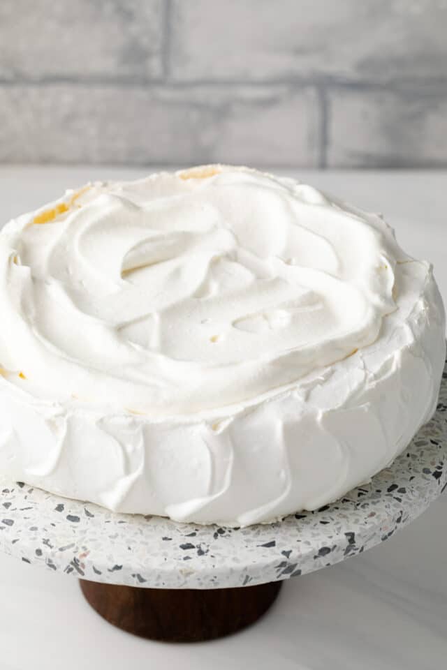 Whipped cream spread over pavlova.