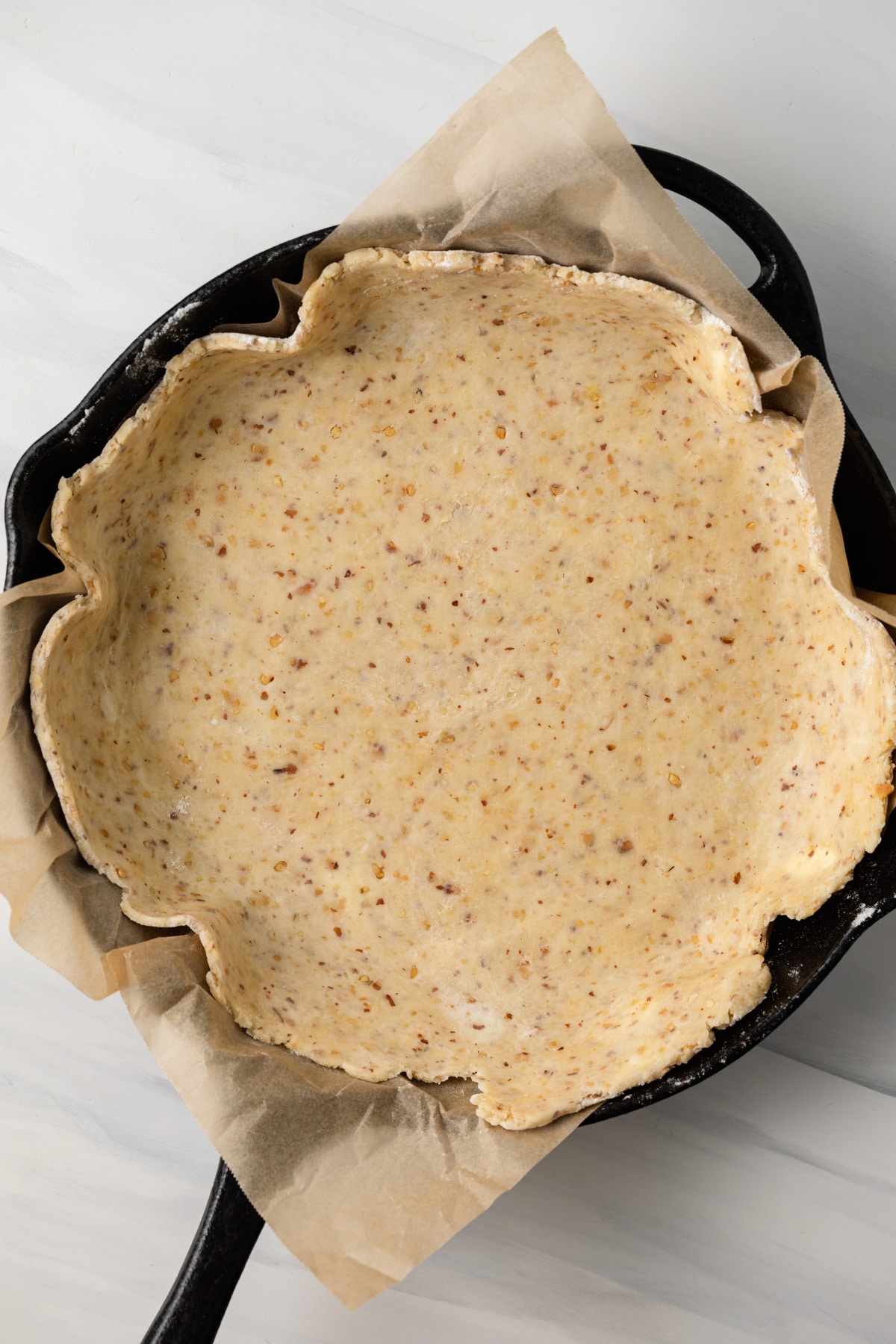 Almond pastry dough rolled into cast iron skillet.