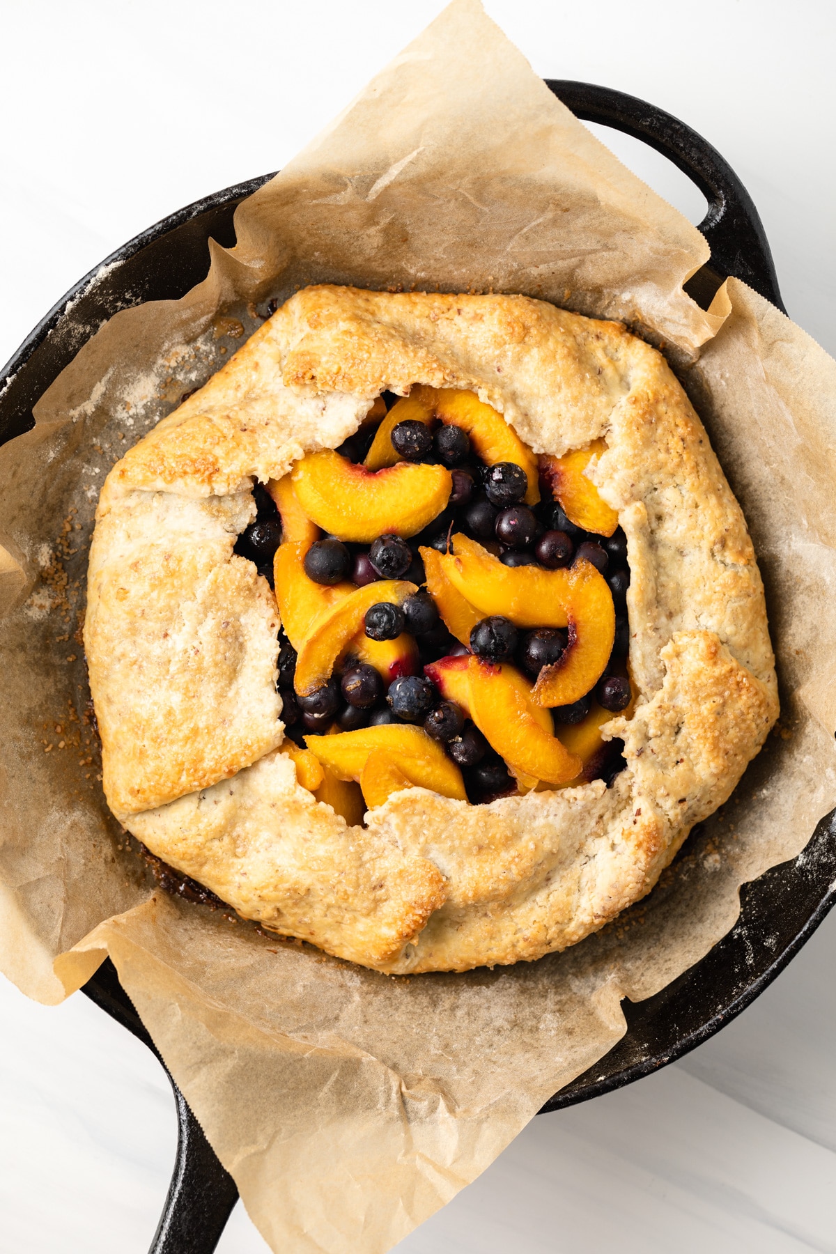 Peach blueberry galette in cast iron skillet.