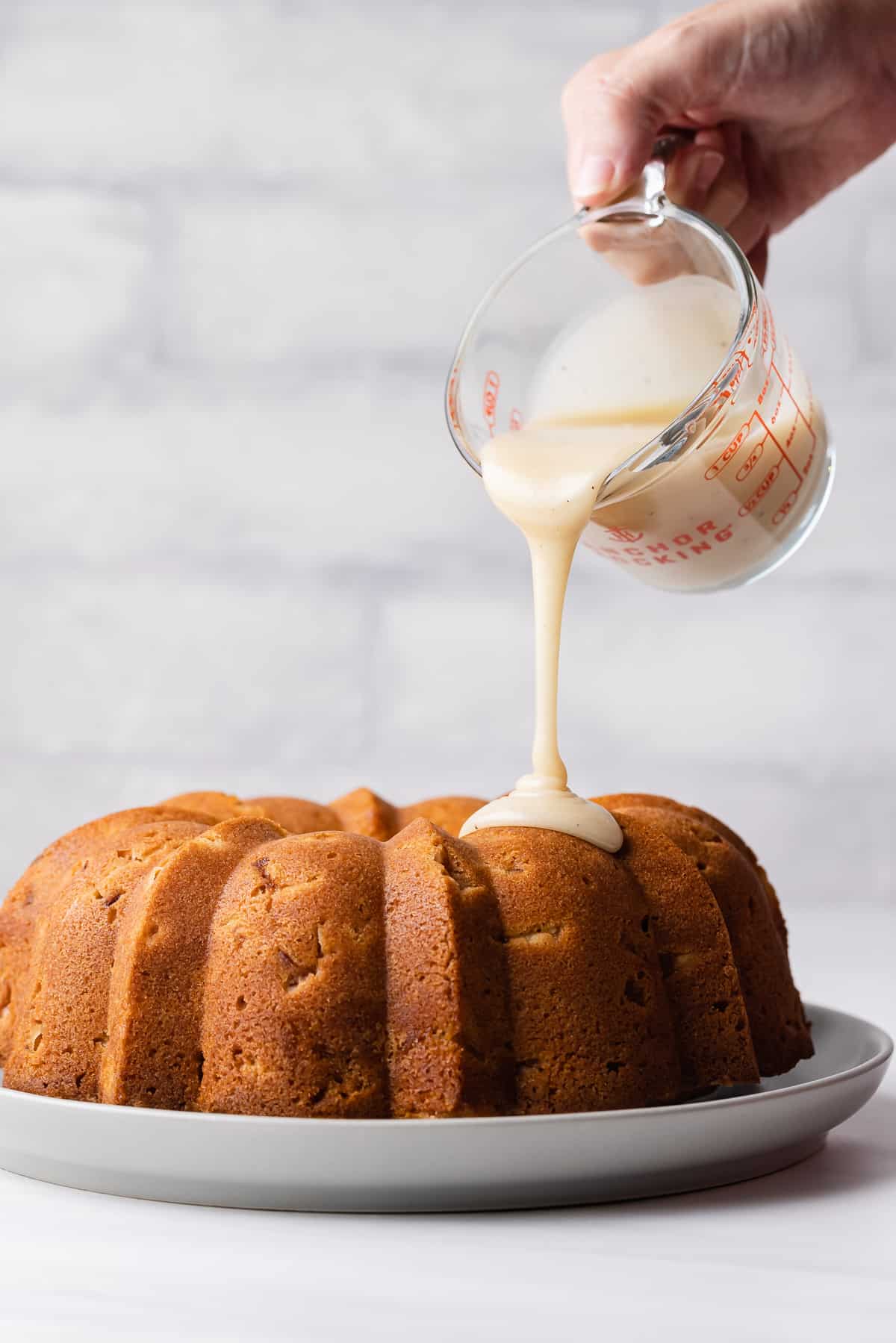 Glaze being poured over a peach pound cake