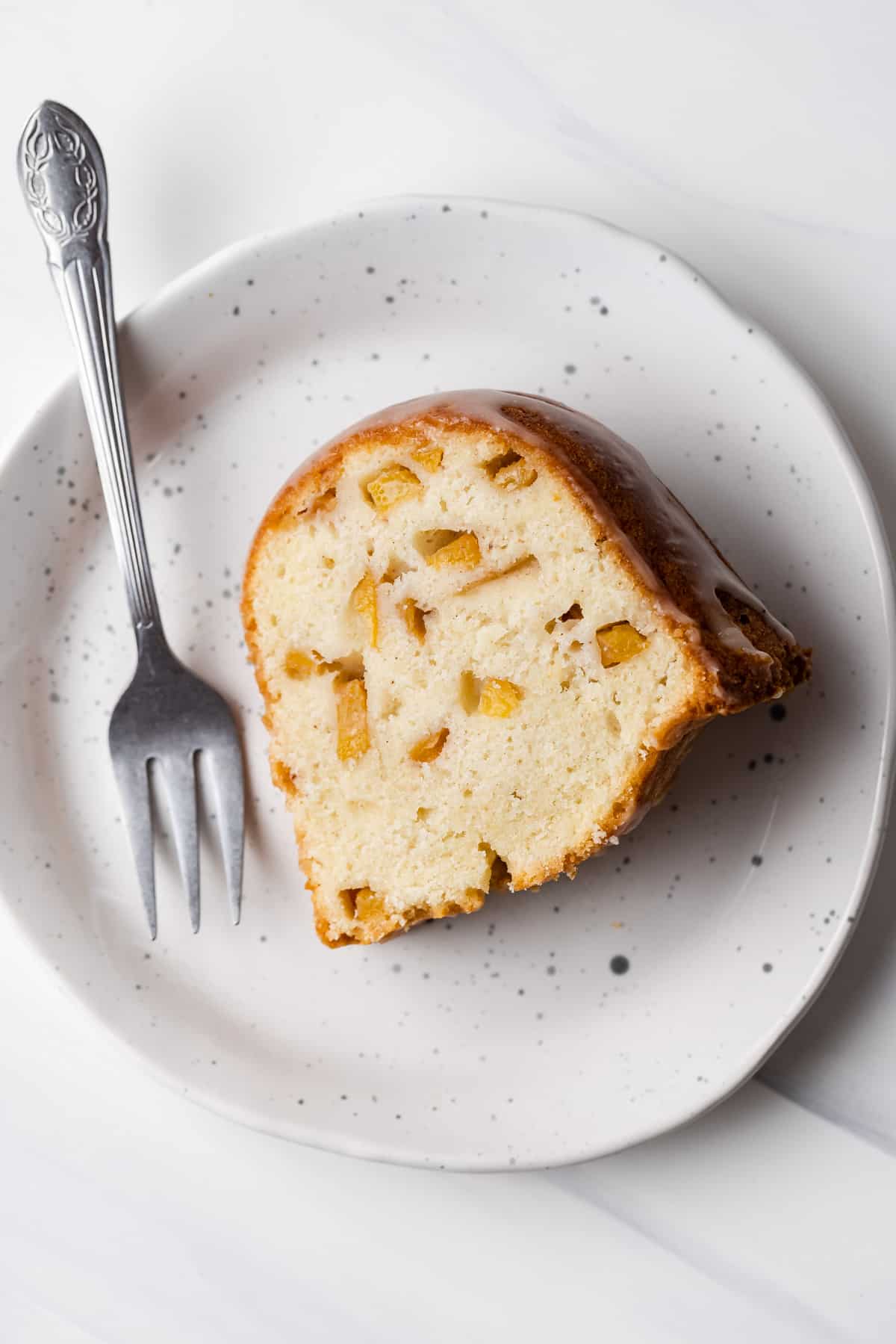 A slice of peach pound cake on a plate