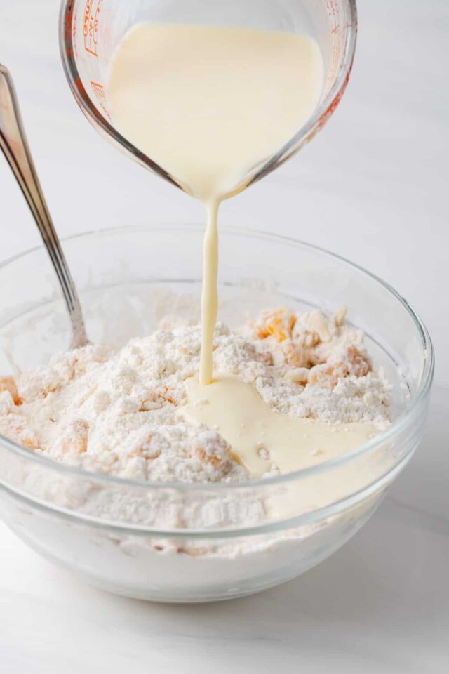Buttermilk being poured into pastry dough