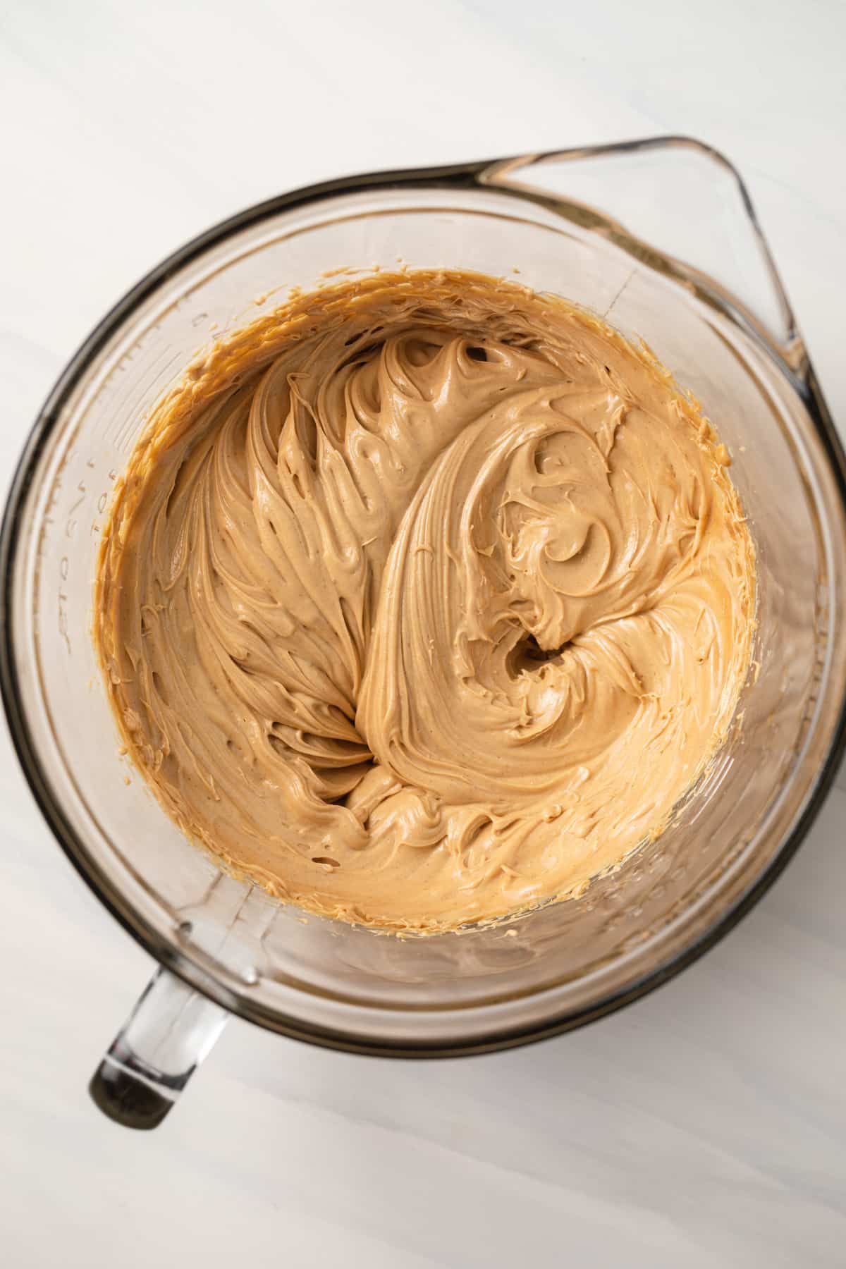 Creamed butter and peanut butter in glass bowl.
