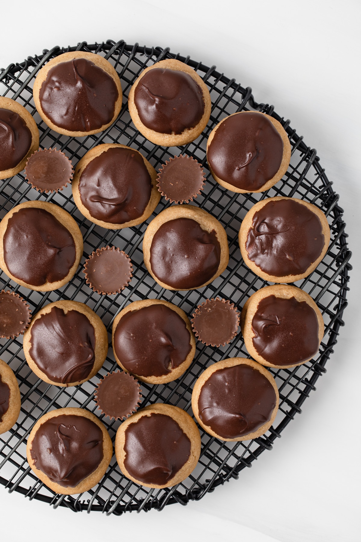 Overhead view of peanut butter cup cookies on wire rack.