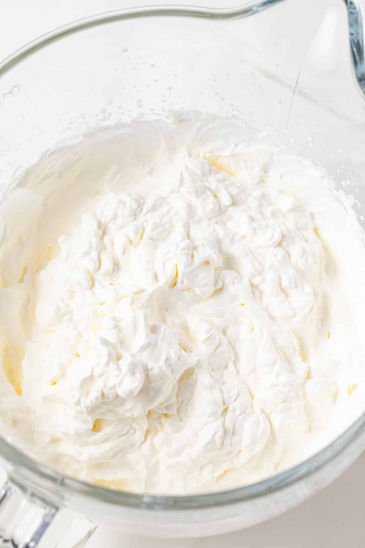Whipped heavy cream in a glass bowl.