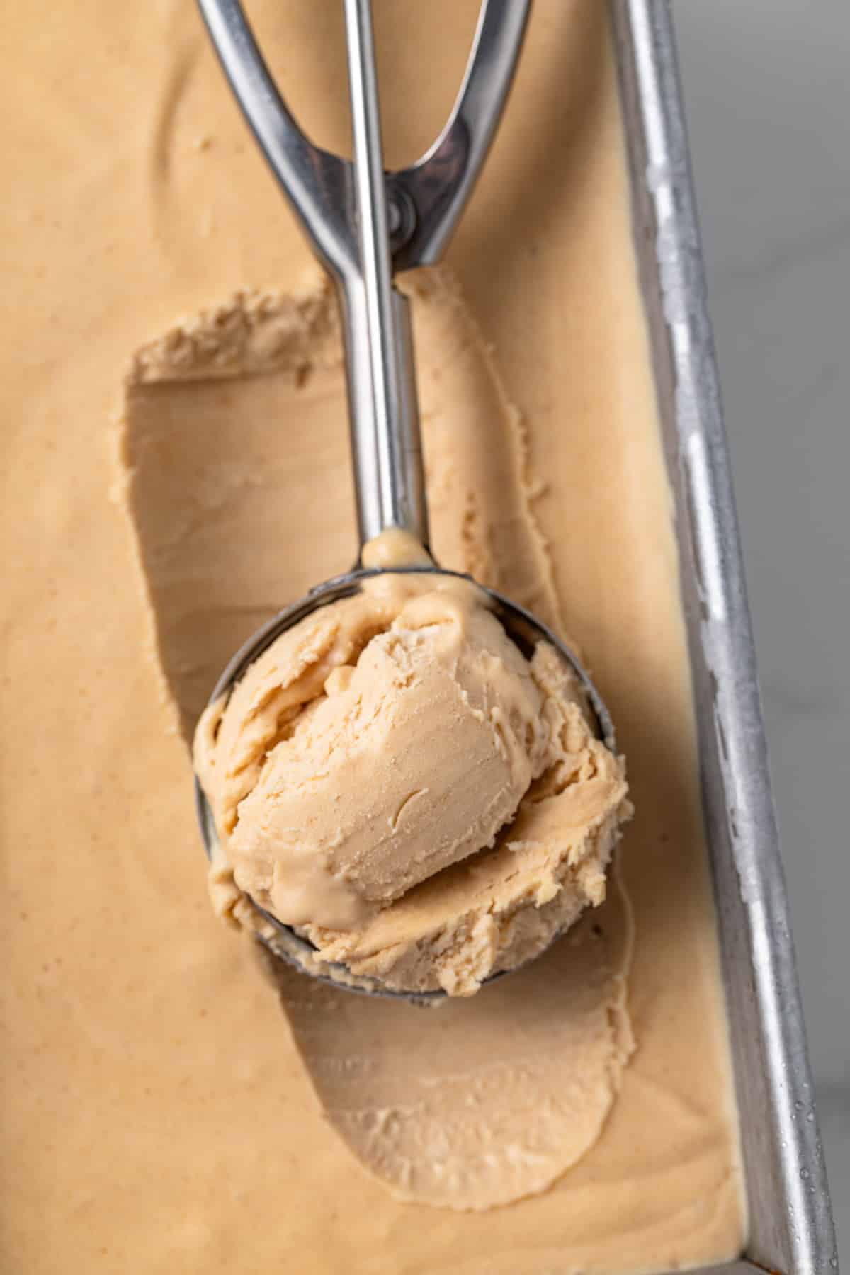 Overhead view of a scoop with peanut butter ice cream.