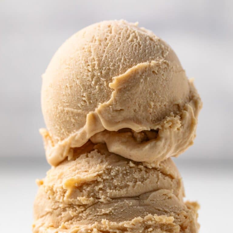 Two scoops of peanut butter ice cream on a cone.