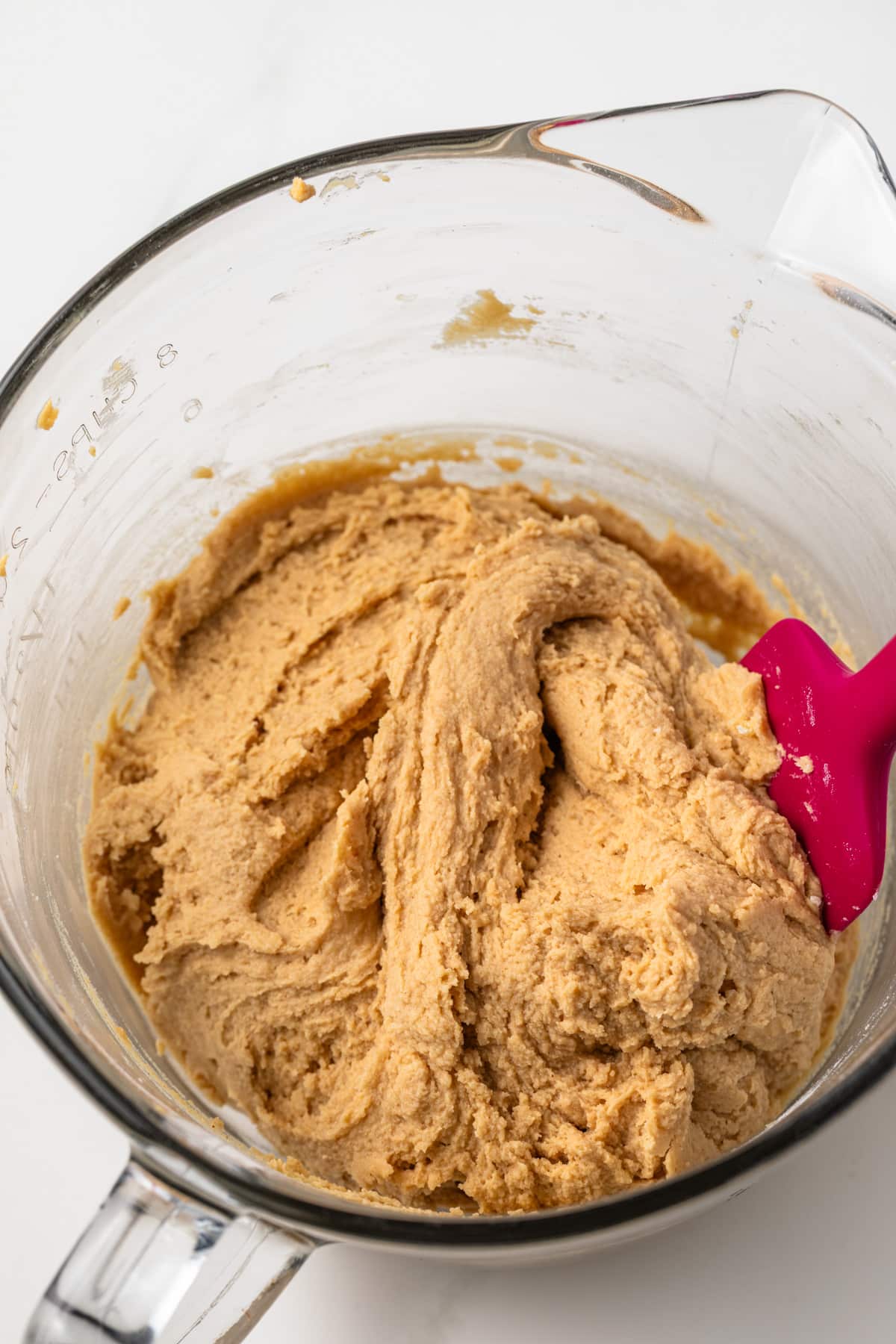 Peanut butter cookie dough in glass bowl.
