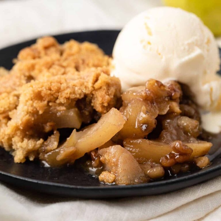 Pear walnut crisp with vanilla ice cream on a plate