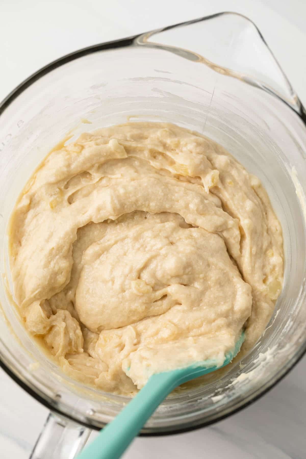 Pineapple cupcake batter in a glass bowl.