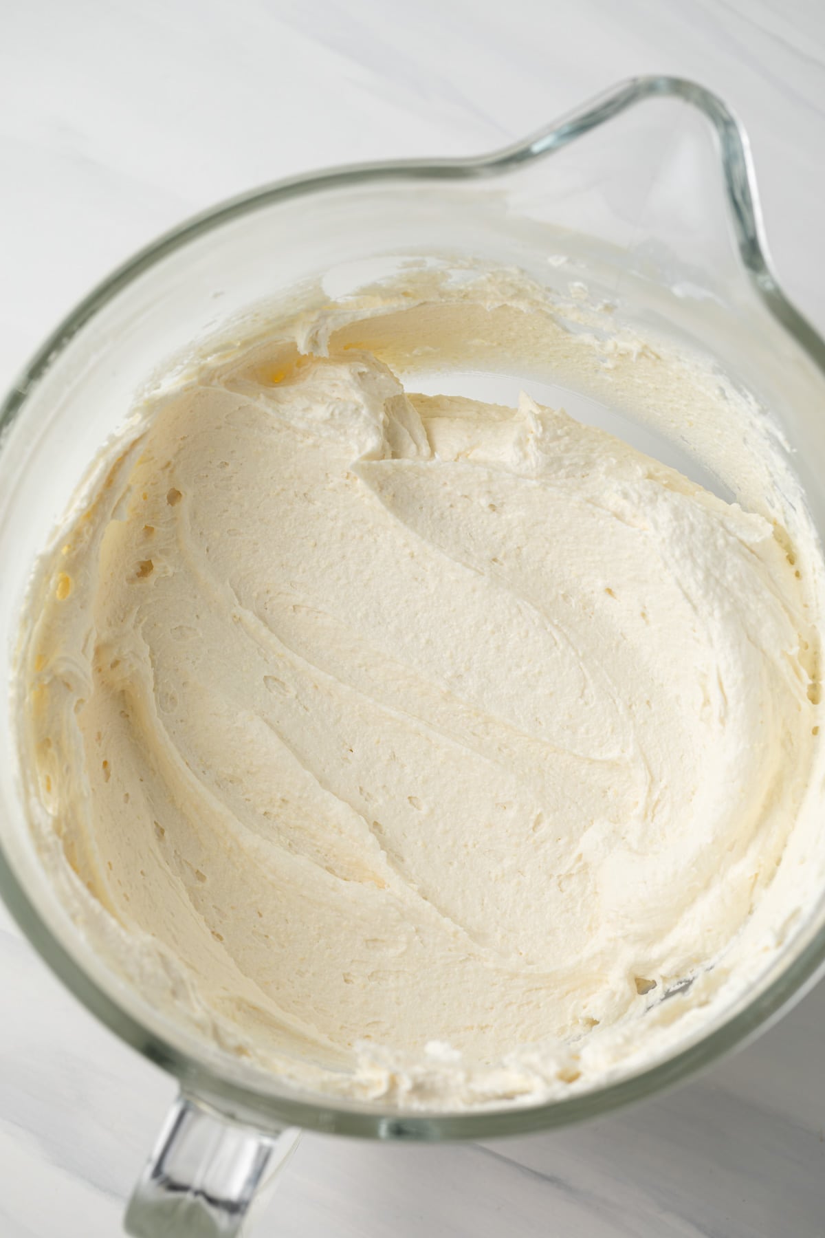 Pineapple frosting in a glass bowl.