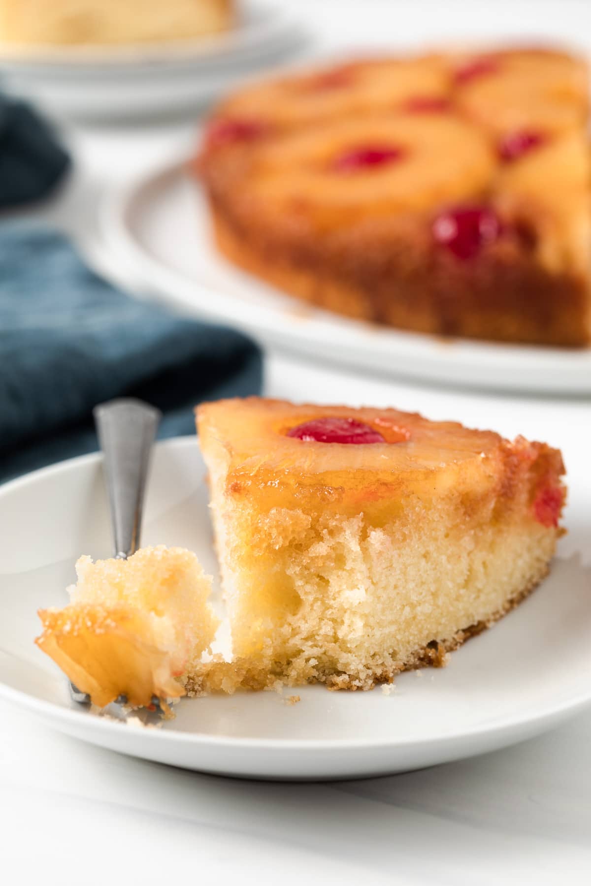 slice of homemade pineapple upside down cake with a fork taking out a bite
