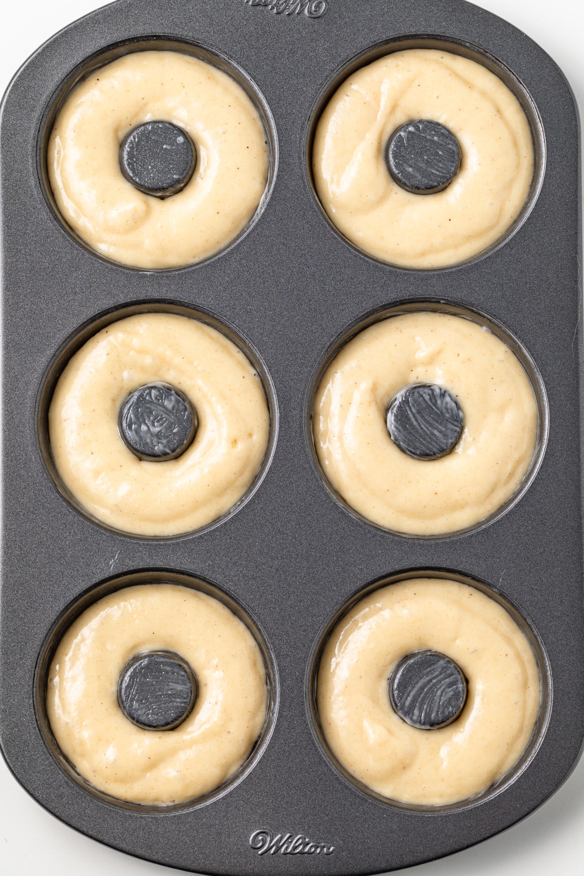 Unbaked donuts in donut pan.