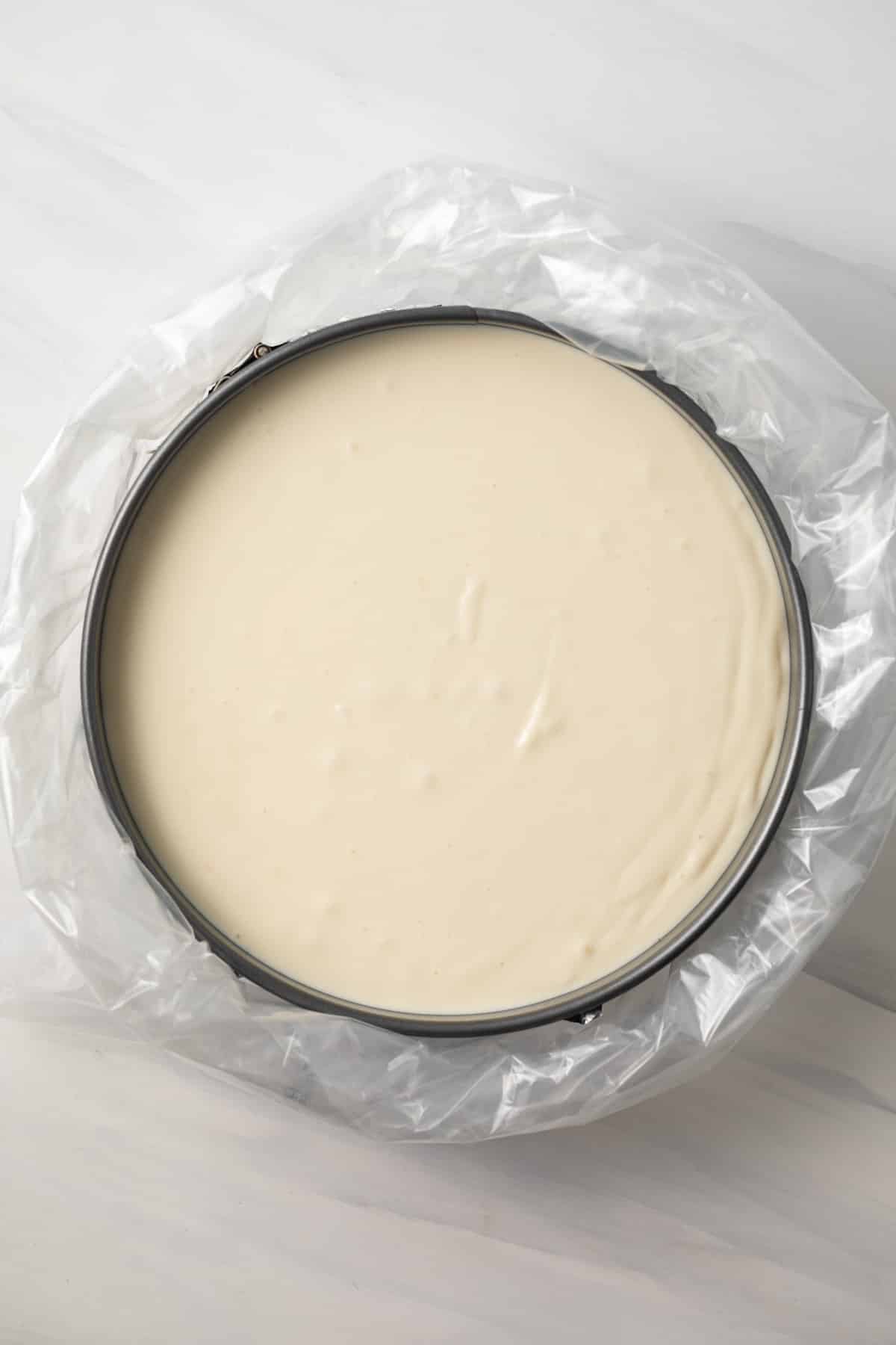 Overhead of cheesecake in water bath.