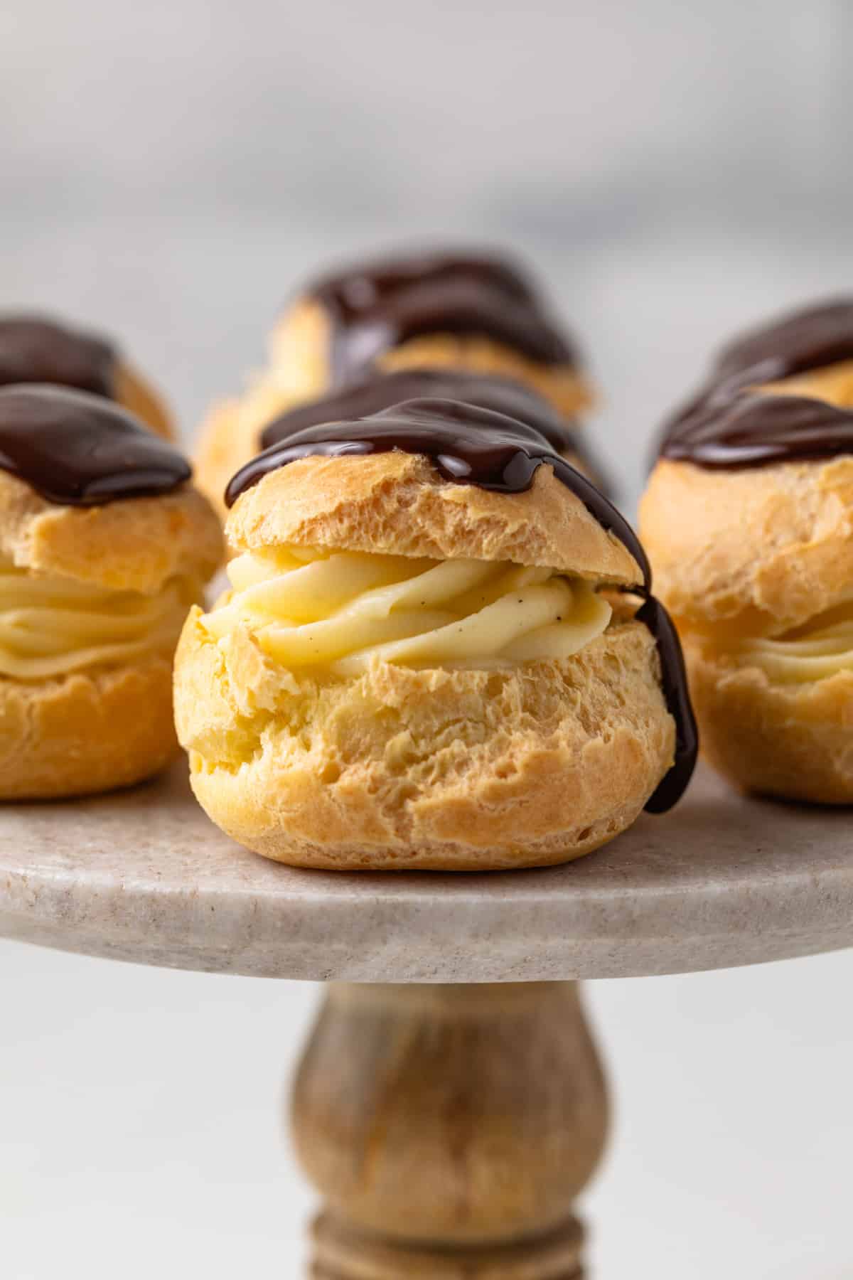 Side view of profiteroles on a cake stand.