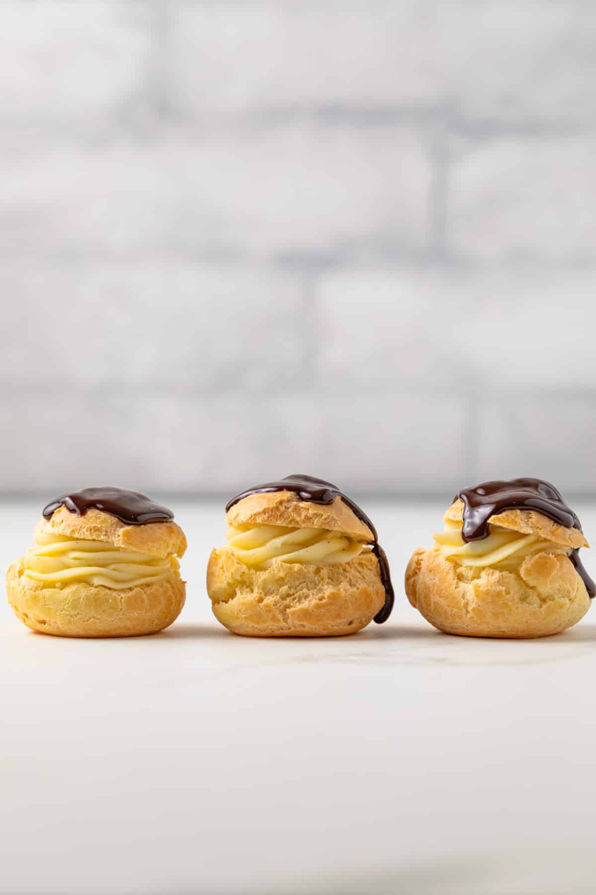 Three profiteroles on a countertop.