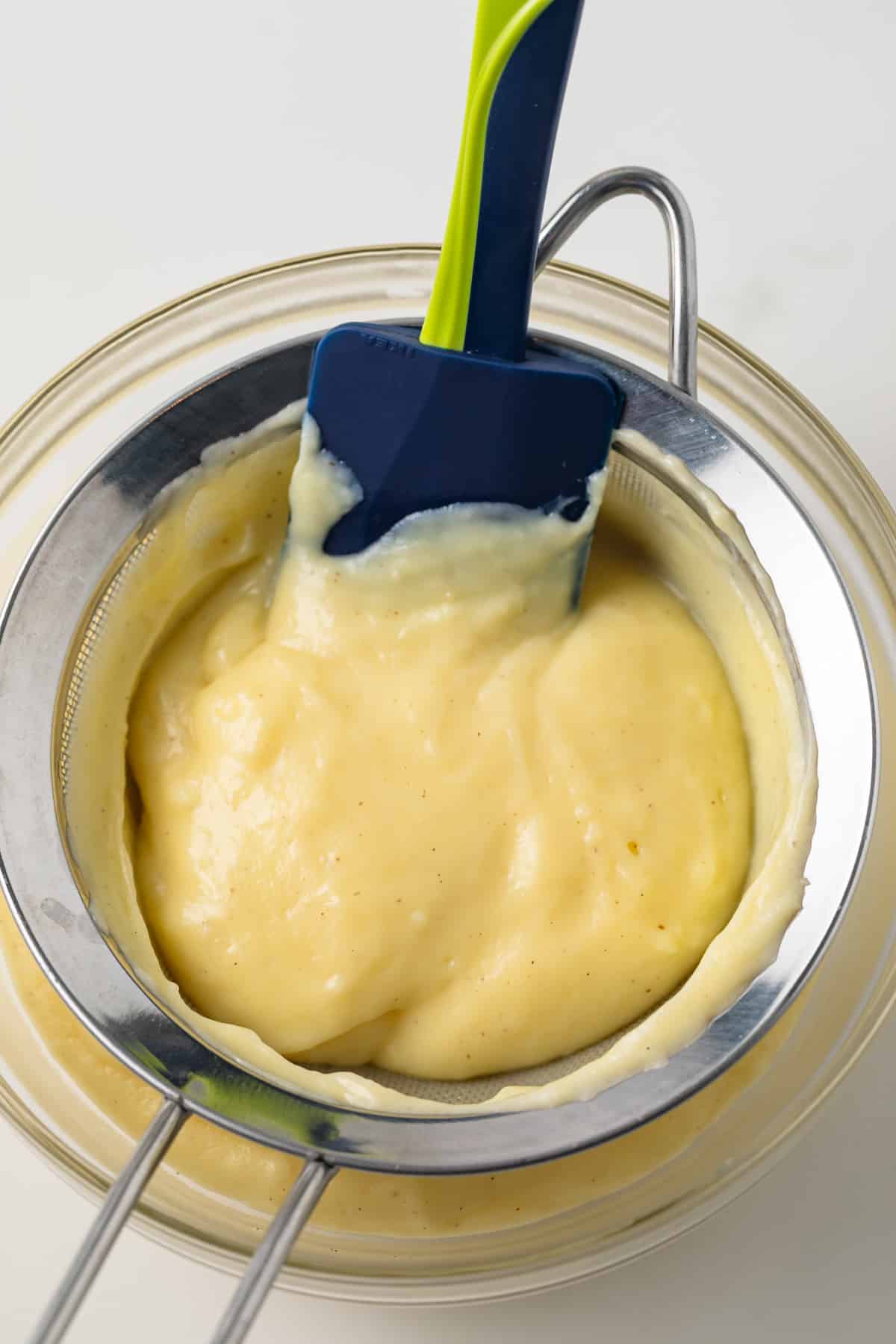 Pastry cream in a metal sieve.
