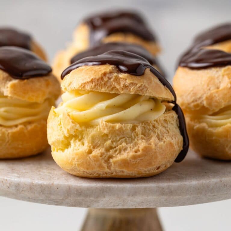 Side view of profiteroles on a cake stand.