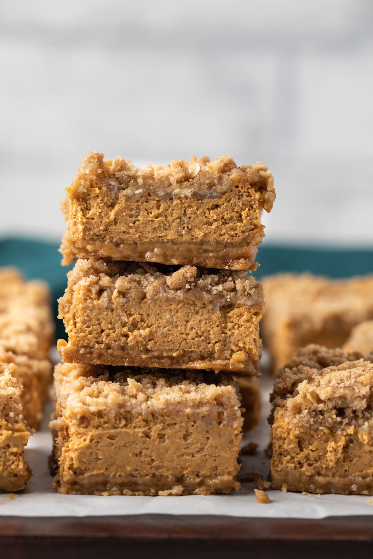 stack of pumpkin bars on brown board with parchment paper