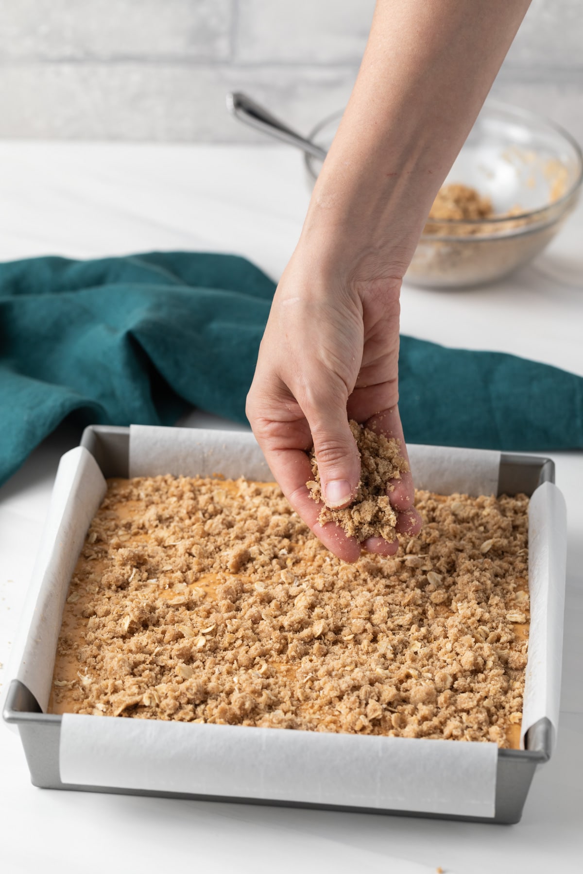 topping sprinkled over unbaked pumpkin bars in pan