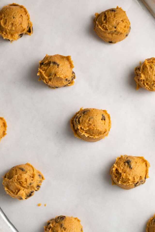 Balls of chocolate chip pumpkin cookie dough ready to be baked