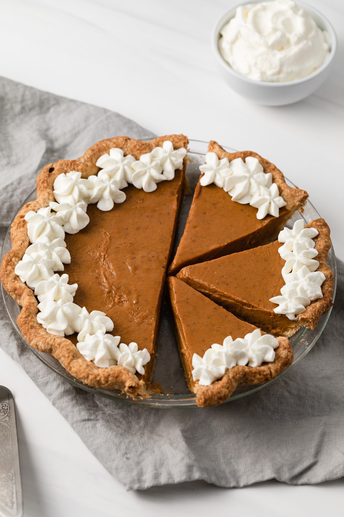 angled view of pumpkin pie with slices cut