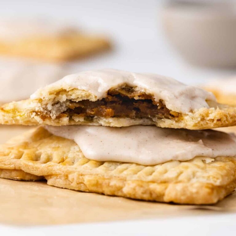 Two pumpkin pie pop tarts with cinnamon glaze, the top one missing a few bites