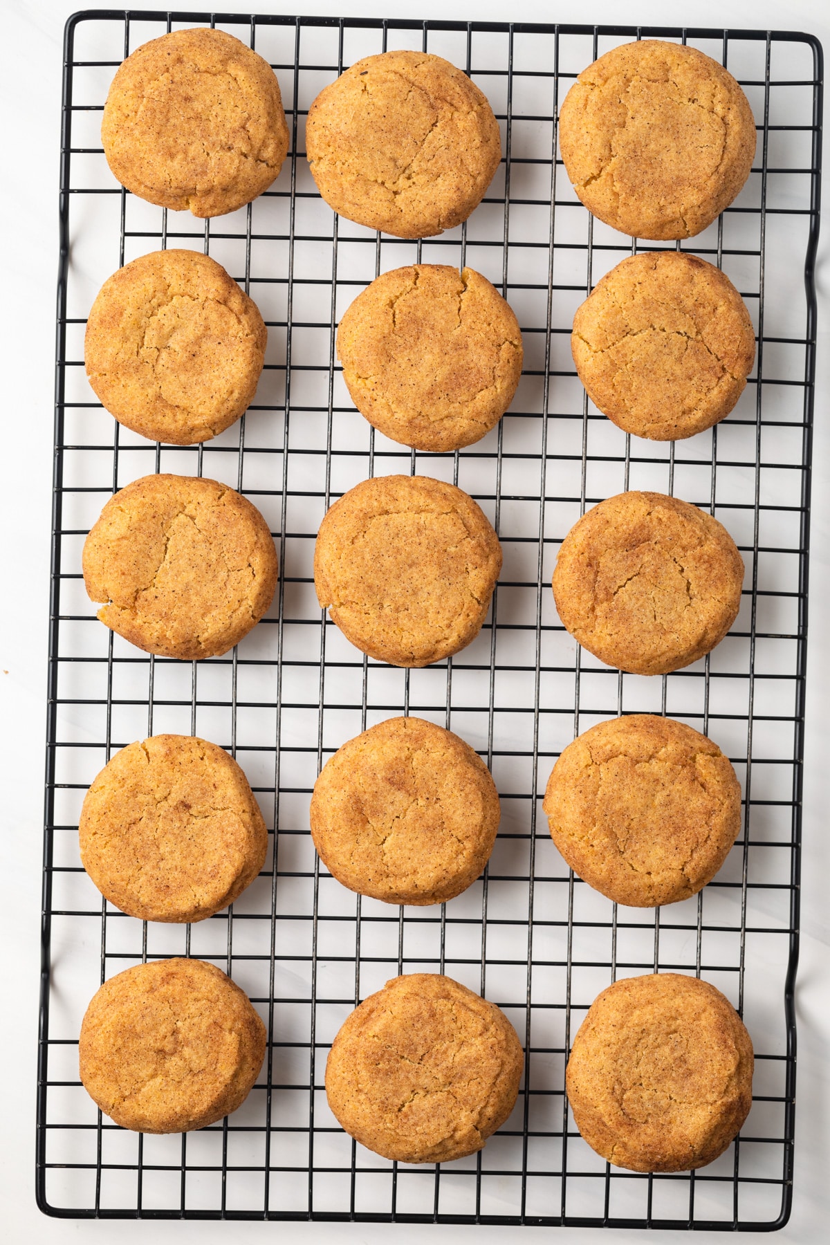 Overhead of pumpkin snickerdoodles on wire rack.