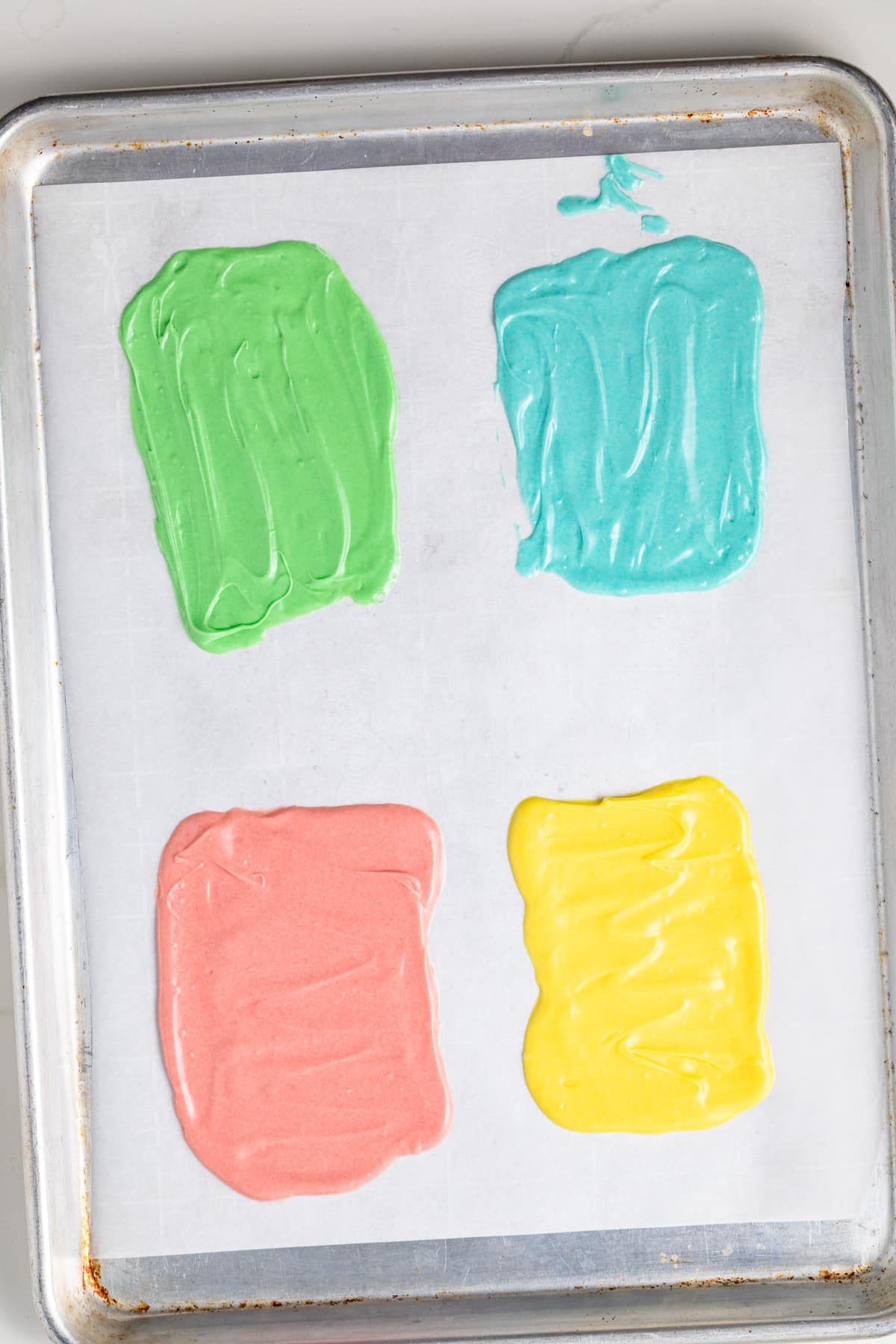 Colored white chocolate spread on parchment paper.