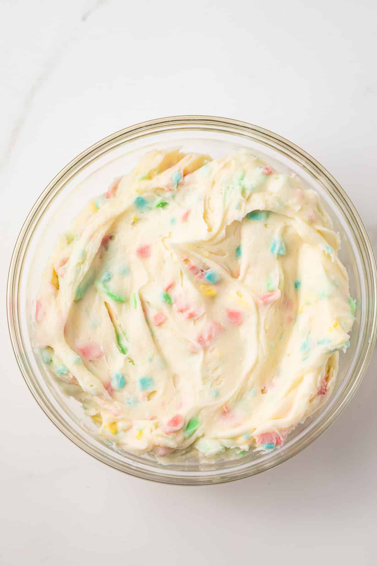 Glass bowl of rainbow chip frosting.