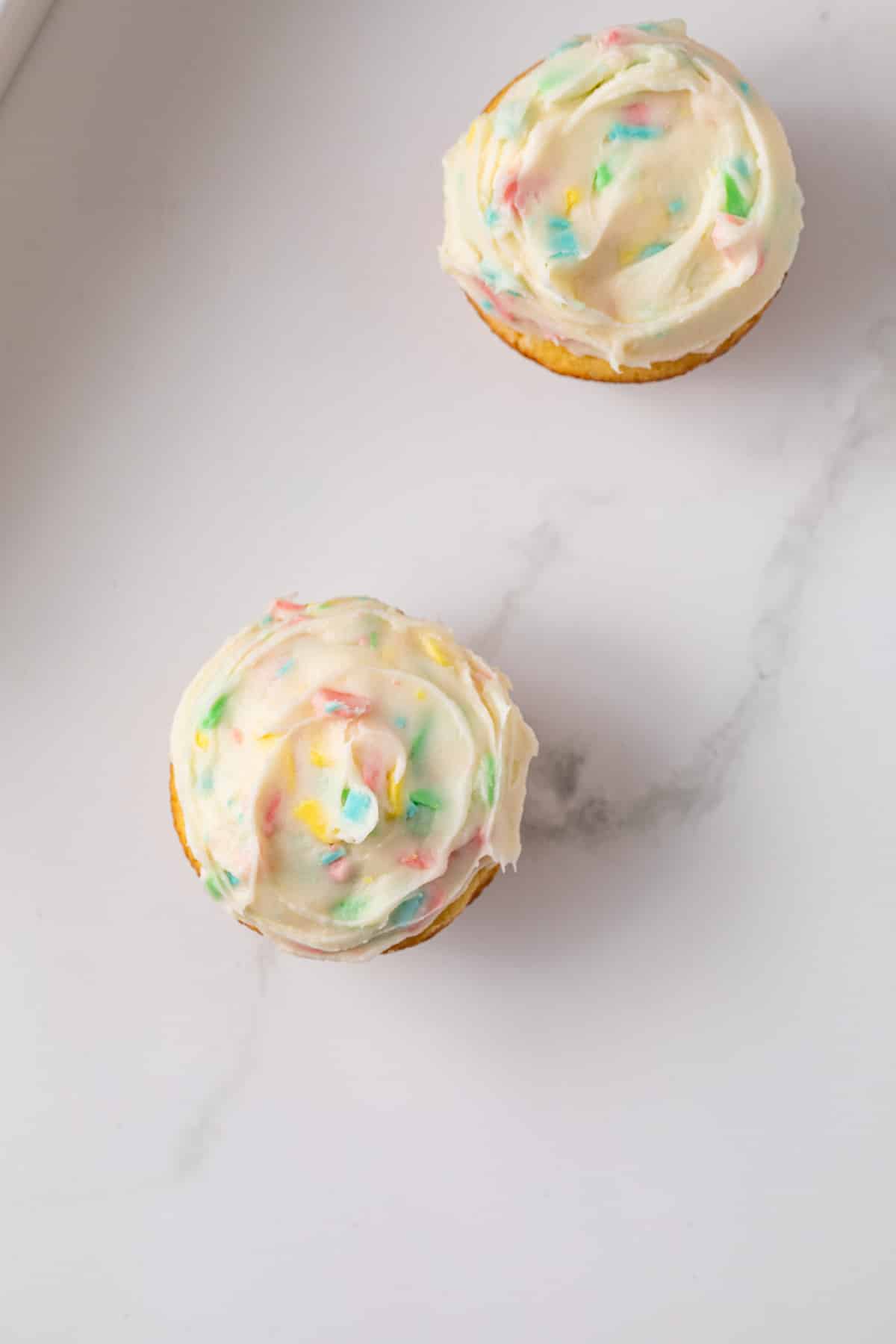 Overhead of rainbow chip frosting on cupcakes.